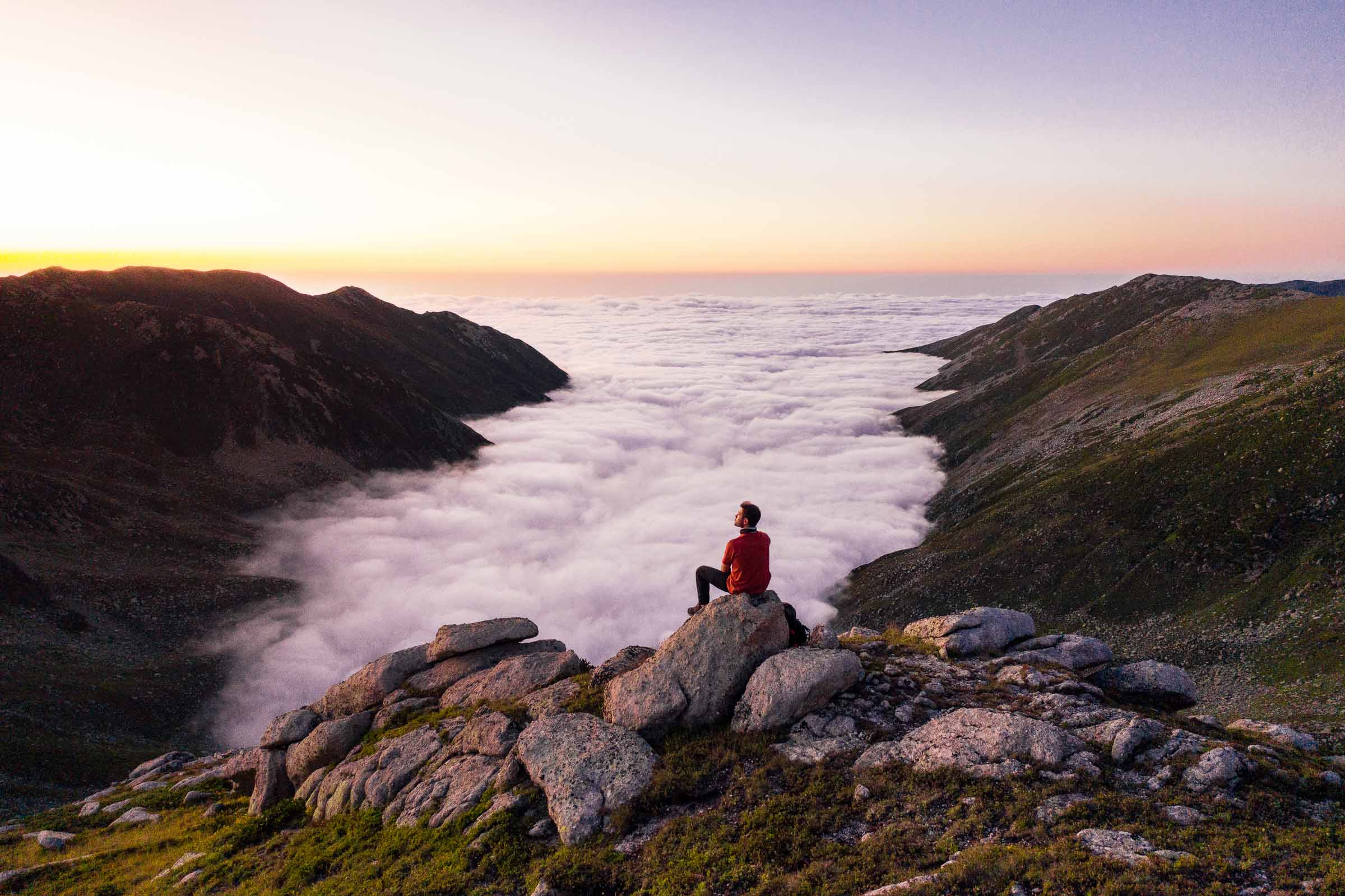 Walker on a rocky ridge above a sea of clouds in the Kaçkar Mountains