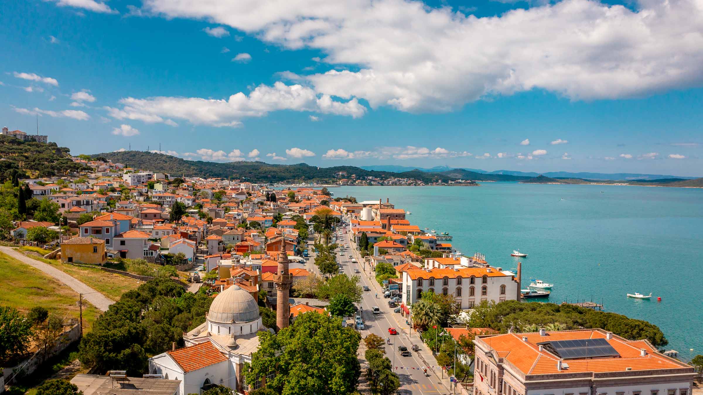 Aerial view of Ayvalık's red roofs and minaret along the bay