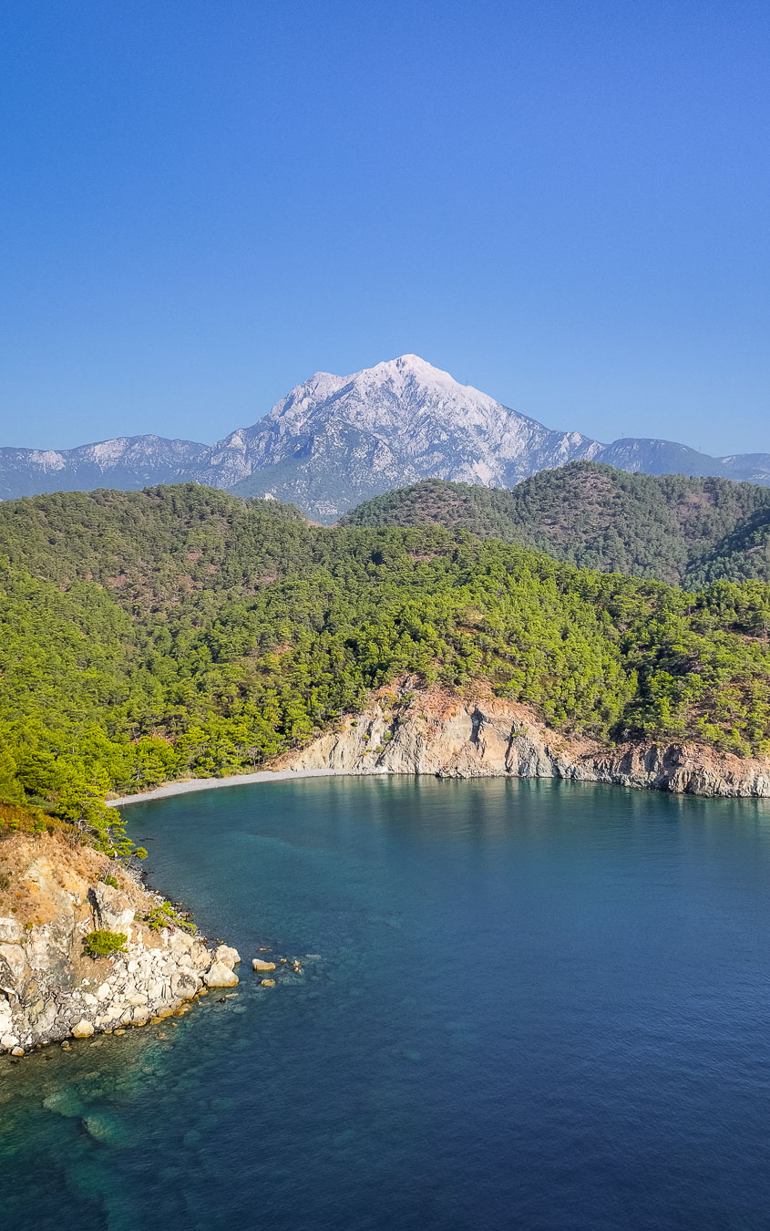 A pine-covered bay with clear water below Mount Tahtalı near Kemer