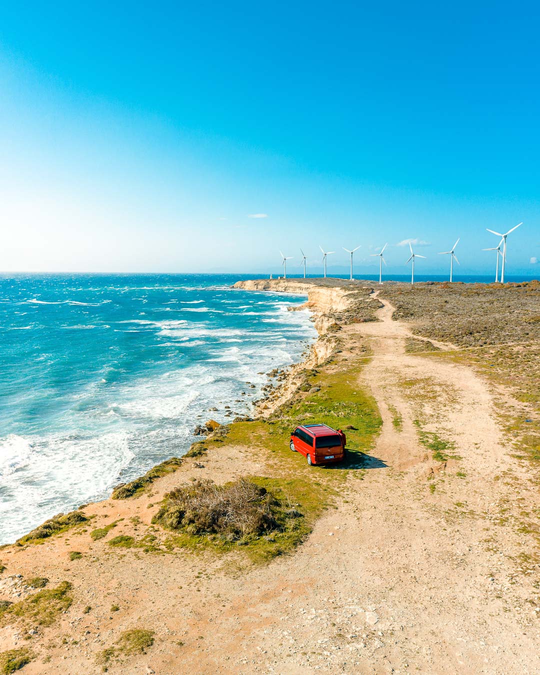 The coast near the Polente Lighthouse on Bozcaada, with wind turbines on the ridge