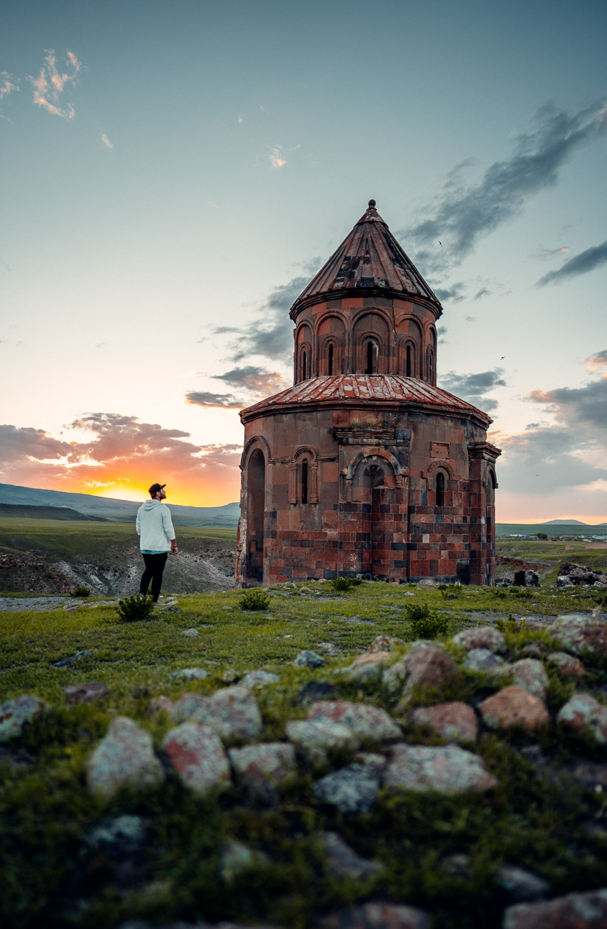 A visitor beside a ruined medieval church at Ani, Kars, in evening light
