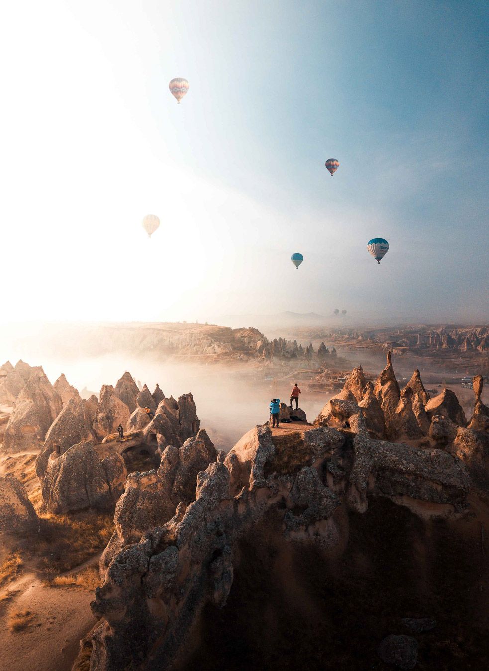 Hot-air balloons rising over the rock formations of Cappadocia at sunrise